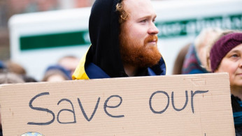 Person holding save our planet sign.