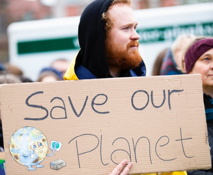 Person holding save our planet sign.