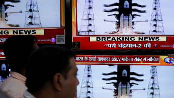People watch a live broadcast of India's second lunar mission, Chandrayaan-2, inside an electronics showroom in Kolkata, India, July 22, 2019.