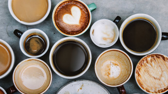 Top view photo of ceramic mugs filled with coffee.