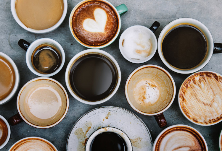 Top view photo of ceramic mugs filled with coffee.