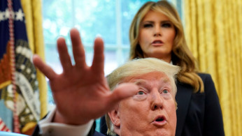 First lady Melania Trump listens as U.S. President Donald Trump speaks to reporters while hosting Team USA for the 2019 Special Olympics World Games in the Oval Office of the White House in Washington, U.S., July 18, 2019.