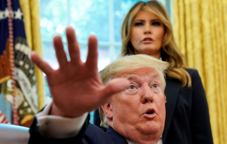 First lady Melania Trump listens as U.S. President Donald Trump speaks to reporters while hosting Team USA for the 2019 Special Olympics World Games in the Oval Office of the White House in Washington, U.S., July 18, 2019.