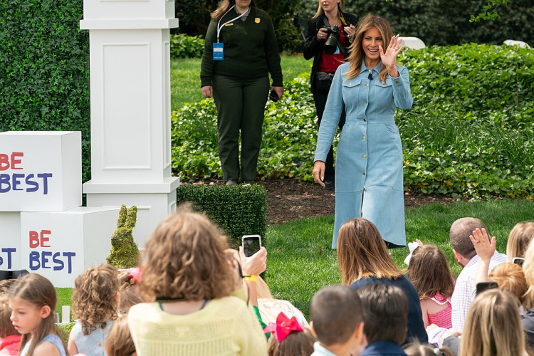 First Lady Melania Trump waves to children on the South Lawn of the White House Monday, April 22, 2019, before reading a story at the reading nook during the 141st White House Easter Egg Roll.