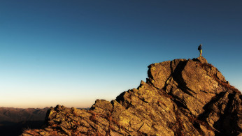 Man standing on top of rock at day time.