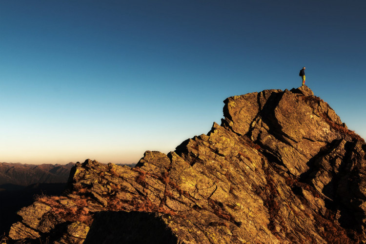 Man standing on top of rock at day time.