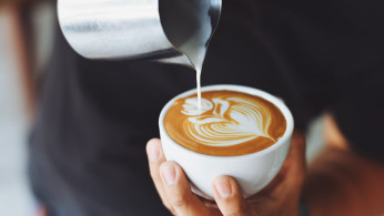 Person performing coffee art.