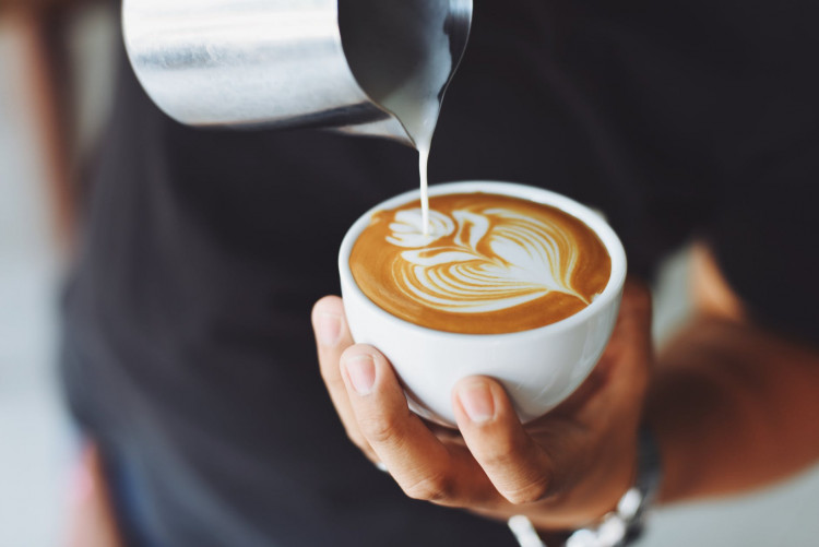 Person performing coffee art.