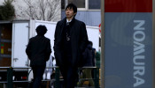 A man walks past a signboard of Nomura Securities outside its branch in Tokyo