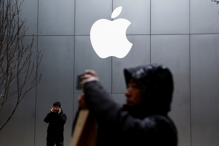 People use their phones outside an Apple store in Beijing, China 