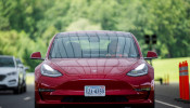 IIHS media relations associate Young demonstrates front crash prevention test on Tesla Model 3 at IIHS-HLDI Vehicle Research Center in Ruckersville, Virginia