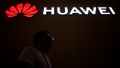  A man walks past a sign board of Huawei at CES (Consumer Electronics Show) Asia 2018 in Shanghai