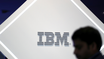 A man stands near an IBM logo at the Mobile World Congress in Barcelona