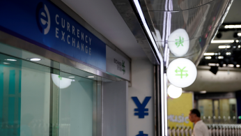 Signs of Chinese yuan and U.S. dollar are seen at a currency exchange store in Shanghai