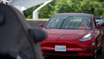 IIHS media relations associate Young demonstrates a front crash prevention test on a Tesla Model 3 at IIHS-HLDI Vehicle Research Center in Ruckersville, Virginia