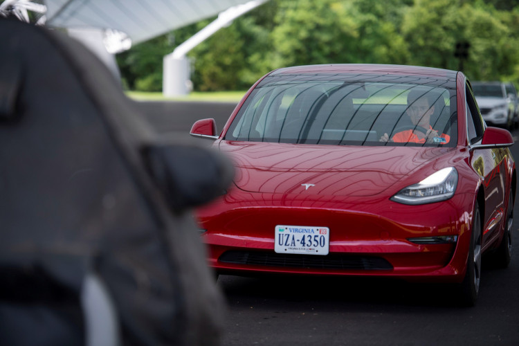 IIHS media relations associate Young demonstrates a front crash prevention test on a Tesla Model 3 at IIHS-HLDI Vehicle Research Center in Ruckersville, Virginia