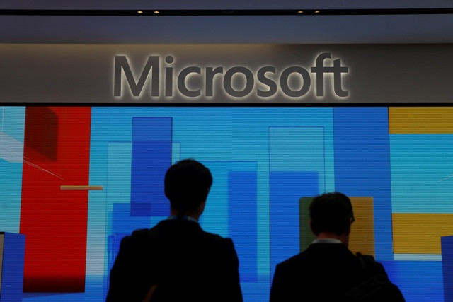 Visitors stand in front of a display screen at Microsoft's Oxford Circus in London