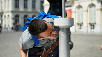 People drink water from a fountain on a hot summer day in Brussels