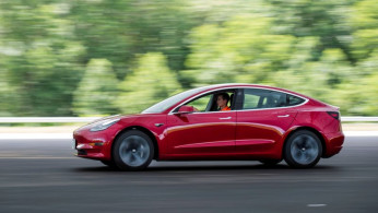 IIHS media relations associate Young drives a Tesla Model 3 at IIHS-HLDI Vehicle Research Center in Ruckersville, Virginia