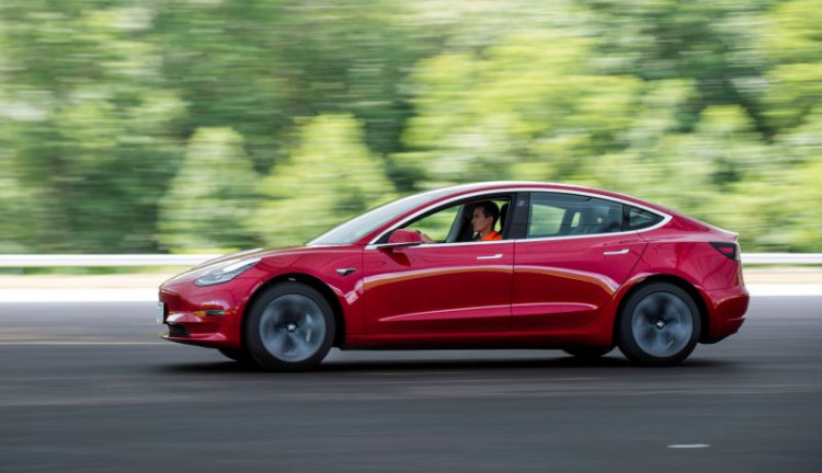 IIHS media relations associate Young drives a Tesla Model 3 at IIHS-HLDI Vehicle Research Center in Ruckersville, Virginia