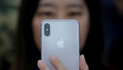 A attendee uses a new iPhone X during a presentation for the media in Beijing 