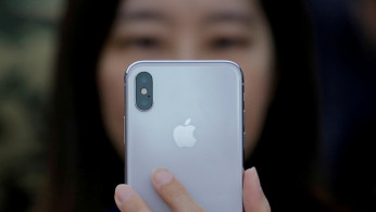 A attendee uses a new iPhone X during a presentation for the media in Beijing 