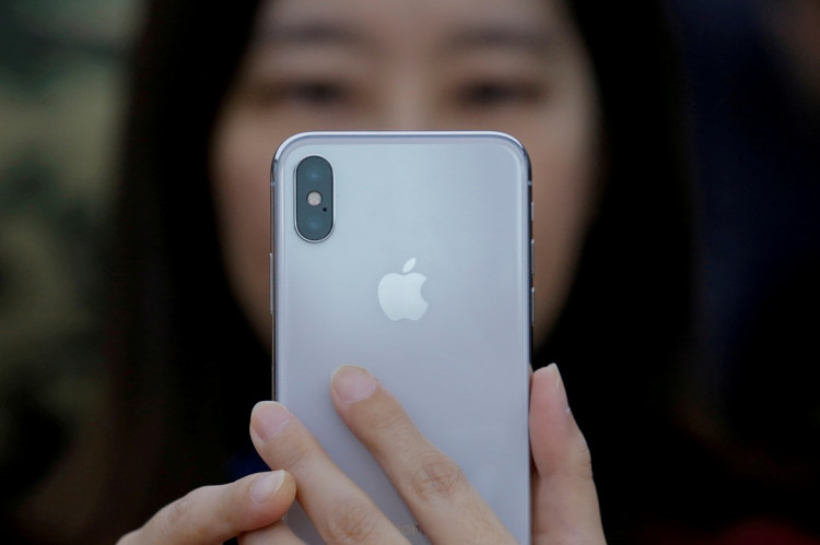 A attendee uses a new iPhone X during a presentation for the media in Beijing 