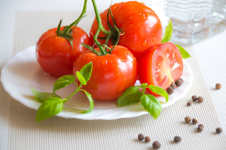 Tomato top of white ceramic plate.