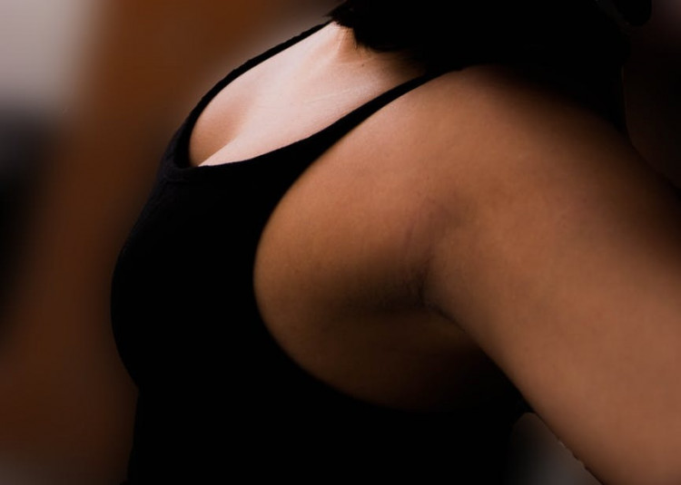 Woman wearing black tank top and sunglasses.