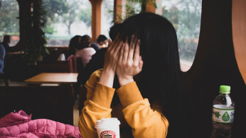 Woman covering her face.