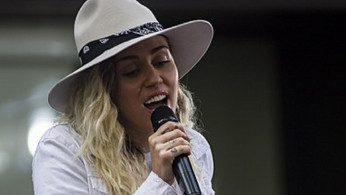 Miley Cyrus ignores Lindsay Lohan's flirty comment on Liam Hemsworth's photo. Photo by Mass Communication Specialist 3rd Class Casey J. Hopkins/Flicker